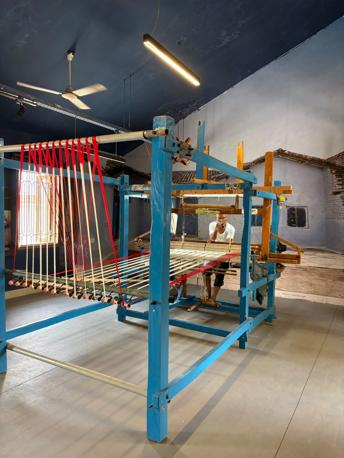 A Pochampally weaver at his pit loom, threading the warp
